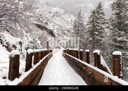 Schneebedeckte alte Holzflöte auf dem Welch Ditch Trail im Clear Creek Canyon im Winter. Teil des Peaks to Plains Trail in der Nähe von Golden, Colorado, USA Stockfoto