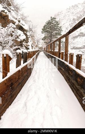 Schneebedeckte alte Holzflöte auf dem Welch Ditch Trail im Clear Creek Canyon im Winter. Teil des Peaks to Plains Trail in der Nähe von Golden, Colorado, USA Stockfoto