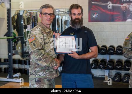 Oberst Matthew Kelly, Befehlshaber des Army Environmental Command, verleiht Kyle Eckert, einem Arzt-Assistenten des World Class Athlete Program, einen Preis während der Besichtigung von Einrichtungen, 20. September 2022. Stockfoto