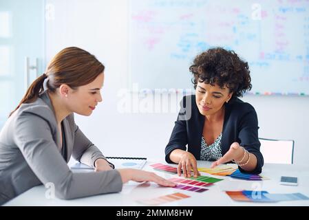 Sieh dir an, wie perfekt das ist. Zwei Designer, die Farbmuster betrachten. Stockfoto