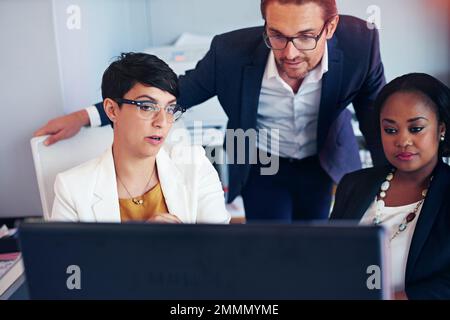 Die Köpfe zusammensetzen. Drei Geschäftskollegen, die im Büro arbeiten. Stockfoto