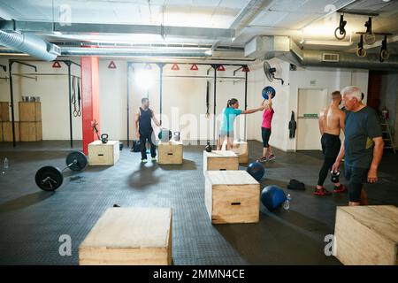 Trainiere mit gleichgesinnten Fitness-Fanatikern. Eine Gruppe von Leuten, die im Fitnessstudio trainieren. Stockfoto