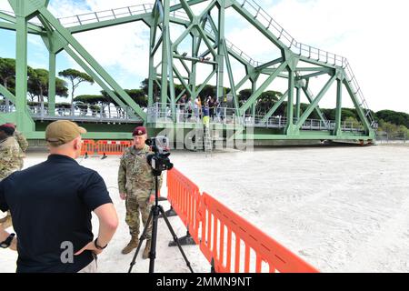 Ein Mitglied der AFN interviewt die Southern European Task Force der US Army, Afrika, die General Maj. General Todd R. Wasmund vor der neuen Drehbrücke über den Navicelli-Kanal in Camp Darby, Pisa Munitionslager, Italien, 21. September 2022. Die Brücke ist Teil des Infrastrukturmodernisierungsprojekts, das die Modernisierung der Kanaldocks und eine sichere Zone zum Be- und Entladen von Munitionsgut umfasst. Das von der US-Regierung finanzierte $42-Millionen-Projekt ist ein wichtiges strategisches Projekt und trägt zur Verbesserung der Sicherheit am Standort bei. Stockfoto