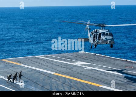 220921-N-UF592-1069 PHILIPPINISCHES MEER (SEPT 21, 2022) Mitglieder der mobilen Einheit für die Entsorgung explosiver Ordnanzen (EODMU) 5, die dem Kommandanten der Task Force (CTF) 70 angeschlossen ist, führen eine HRST-Übung (HRST) mit einem MH-60s Seahawk durch, der an den Golden Falcons of Helicopter Sea Combat Squadron (HSC) 12 befestigt ist, Auf dem Flugdeck des einzigen vorwärts eingesetzten Flugzeugträgers der US Navy, USS Ronald Reagan (CVN 76), in der philippinischen See, September 21. Ronald Reagan, das Flaggschiff der Carrier Strike Group 5, stellt eine kampfbereite Kraft zur Verfügung, die die Vereinigten Staaten schützt und verteidigt und unterstützt Stockfoto