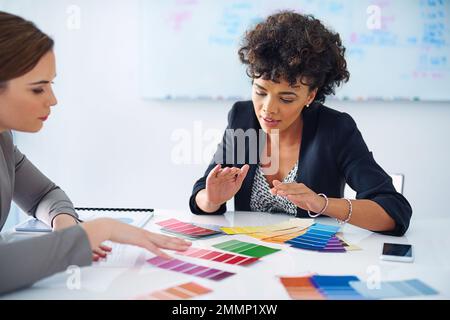 Sie sind ihrer Konkurrenz immer voraus. Zwei Designer, die Farbmuster betrachten. Stockfoto