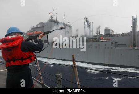 PHILIPPINISCHES MEER (Sept 21, 2022) – Gunners Mate 2. Klasse John Rhodes aus San Antonio feuert eine Schusslinie an Bord des Arleigh Burke-Klasse-Lenkflugkörper-Zerstörers USS Barry (DDG 52) während einer laufenden Auffüllung mit dem trockenen Fracht- und Munitionsschiff USNS Carl Brashear der Lewis- und Clark-Klasse (T-AKE 7). Barry wird zum Kommandanten der Task Force 71/Destroyer Squadron (DESRON) 15, dem größten vorwärtseingesetzten DESRON der Marine und der wichtigsten Surface Force der US 7.-Flotte, ernannt. Stockfoto