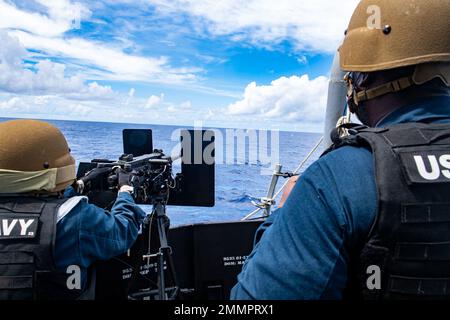 PHILIPPINE SEA (22. September 2022) Chief Gunner's Mate Jeremiah Thomas aus Brooklyn, New York, und Gunner's Mate 2. Class Kayla Vixay aus Fort Worth, Texas, feuert ein Maschinengewehr Kaliber .50 bei einer Schießerei in Live-Feuern an Bord des Arleigh Burke-Klasse geführten Raketenzerstörers USS Milius (DDG 69) Während des Betriebs in der Philippinischen See, September 22. Milius ist dem Befehlshaber, der Task Force 71/Destroyer Squadron (DESRON) 15, der größten nach vorn eingesetzten DESRON der Marine und der Hauptstreitkräfte der US-7.-Flotte zugewiesen. Stockfoto