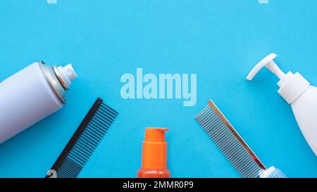 Klassische Schneide- und Friseurwerkzeuge auf blauem Hintergrund: Lack, Kämme, Lotionen. Draufsicht, Layout, Kopierbereich. Stockfoto