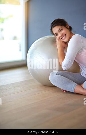 Auf den Ball. Eine sportliche junge Frau, die in ihrer Trainingskleidung gekleidet ist. Stockfoto