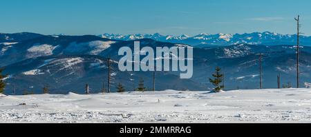 Niedrigere und näher gelegene Hügel der Beskiden und höhere Gipfel der Tatra im Hintergrund von Wierch Wiselka in der Nähe des Barania Gora Hügels im Winter Stockfoto