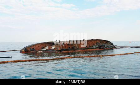 Gesunkenes ertrunkenes Tankschiff nahe dem Grund. Kaputtes rostiges Schiff auf dem flachen Wasser. Stockfoto