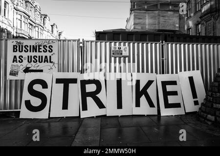 Ein Strike-Plakat neben einem Business-as-usual-Schild Stockfoto