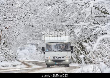 Ein Wohnmobil, das im Winter auf Exmoor, Großbritannien, durch Schneeverhältnisse fährt Stockfoto