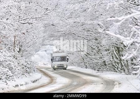 Ein Wohnmobil, das im Winter auf Exmoor, Großbritannien, durch Schneeverhältnisse fährt Stockfoto