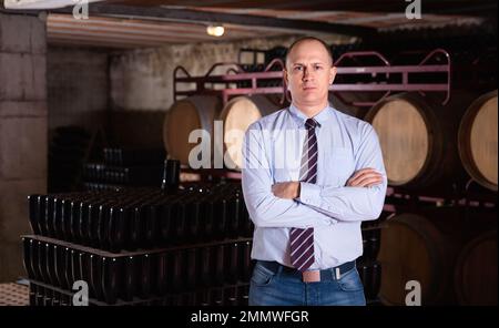 Zuversichtlich erfolgreiche Mann Winzer im eigenen Weingut vault Posing Stockfoto