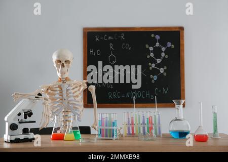 Skelett und verschiedene Chemieglasgeräte im Klassenzimmer Stockfoto