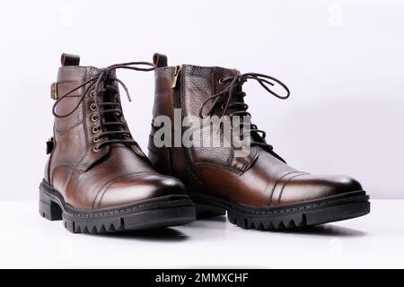 Ein Paar braune Lederstiefel auf weißem Hintergrund. Stockfoto