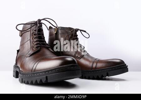 Ein Paar braune Lederstiefel auf weißem Hintergrund. Stockfoto