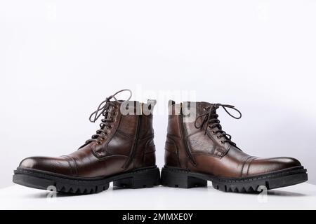 Ein Paar braune Lederstiefel auf weißem Hintergrund. Stockfoto