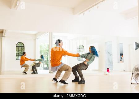 Bild verschiedener weiblicher und männlicher Hip-Hop-Tänzer während des Trainings im Tanzclub. Tanz, Rhythmus, Bewegung und Trainingskonzept. Stockfoto