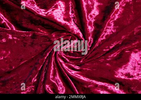 Roter Velor als Nahaufnahme des Hintergrunds verknittert, roter Samtstoff Stockfoto