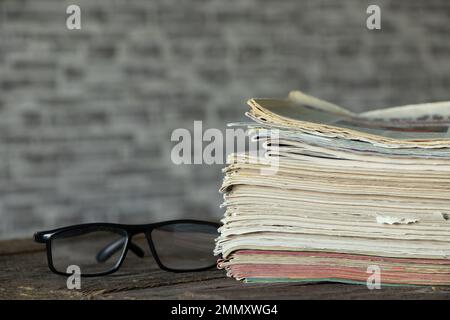 Auf dem Tisch liegt ein Stapel von Zeitschriften und Zeitungen, eine Tageszeitung Stockfoto