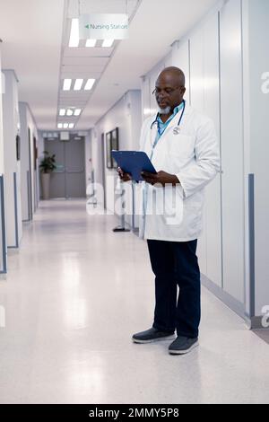 afroamerikanischer Arzt, der im Krankenhaus arbeitet, hält Klemmbrett Stockfoto