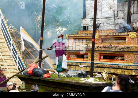 Einäscherungszeremonie für ein Mitglied der Familie Korolev auf der Insel Bali. Arbeiter, die den Altar nach der Einäscherung löschen. Bali, Indonesien - 03,02. Stockfoto