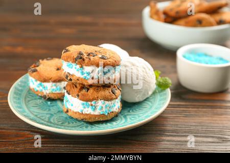 Süße leckere Eis-Kekse-Sandwiches auf einem Holztisch Stockfoto