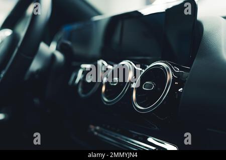 Elegantes, schwarzes Interieur eines modernen Sportwagens mit Klimaanlage und moderner Technologie. Nahaufnahme im Innenbereich. Hochwertiges Foto Stockfoto