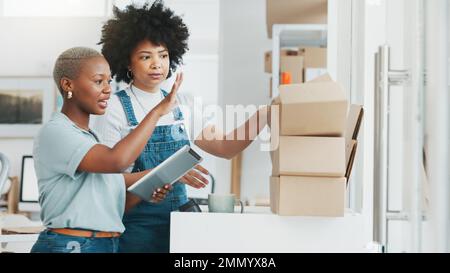 ECommerce-Planung, Versand von Tablets und Frauen, die über Lieferkartons sprechen, Zusammenarbeit mit dem Lager im Büro und Arbeit im Einzelhandel Stockfoto