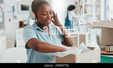 Schwarze Frau, Musik-Kopfhörer und Tanz im Büro, E-Commerce-Logistikunternehmen oder kreatives E-Commerce-Startup. Lächeln, glücklich und aufgeregt Stockfoto