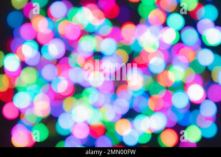 Bunte, verschwommene Lichtkreise auf schwarzem Hintergrund. Farbenfrohe Bokeh-Kulisse Stockfoto