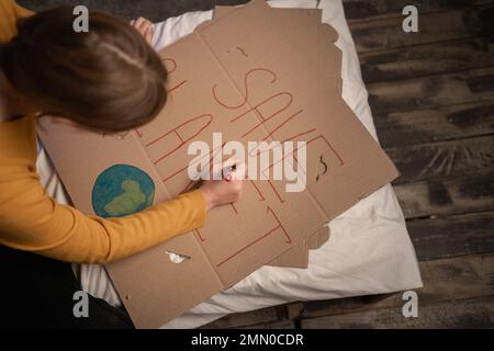 Teenager-Mädchen, die Plakate für Protest für Save Planet macht. Stockfoto