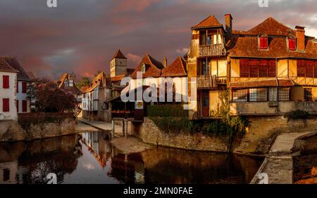 Frankreich, Pyrenäen Atlantiques, Bearn, Salies de Bearn, Fluss, der das historische Stadtzentrum der Marktstadt Salies bei Sonnenuntergang unter bewölktem Himmel kreuzt Stockfoto