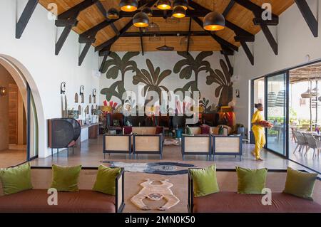 Senegal, Saloum Delta, UNESCO-Weltkulturerbe, Palmarin, Yokan Lodge, Kellnerin, die eine zeitgenössische und tropische Lounge durchquert Stockfoto