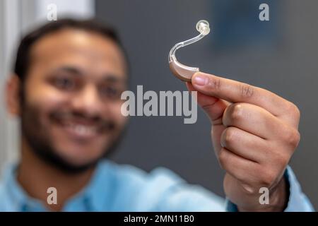 Lächelnder junger Mann mit Hörgerät Stockfoto