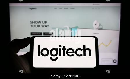 Person, die ein Smartphone mit dem Logo des Schweizer Unternehmens Logitech International S.A. auf dem Bildschirm vor der Website hält. Konzentrieren Sie sich auf das Display des Telefons. Stockfoto