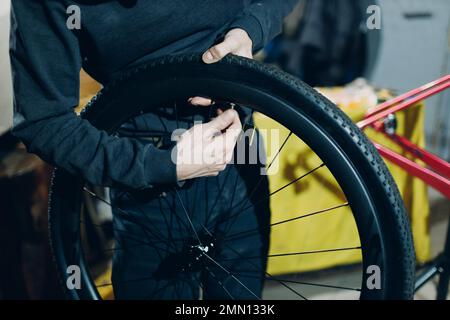 Mechaniker, der die Felge des Radnippels in der Werkstatt zusammenbaut Stockfoto