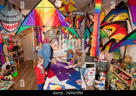 Niederlande, Amsterdam, Europa. Vater und Tochter kaufen einen Drachen in einem speziellen Drachenladen. Stockfoto