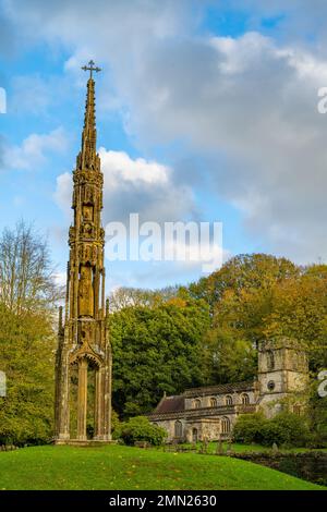 Bristol High Cross das Denkmal, das in das Stourhead-Anwesen in Wiltshire verlegt wurde. Mit der Kirche St. Peters dahinter. Stockfoto