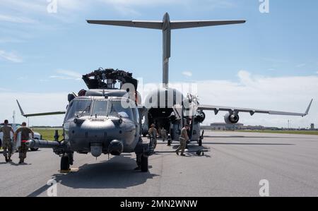 Zwei HH-60G Pave Hawk-Hubschrauber warten darauf, in die Rückseite eines C-17 Globemaster-Flugzeugs auf der Patrick Space Force Base, Florida, am 26. September 2022 geladen zu werden, um sich auf die Ankunft des US-Weltraumflugzeugs Ian vorzubereiten. Die Entscheidung wurde getroffen, die Flugzeuge in Bereiche zu verlegen, die Schäden verhindern würden. In weniger als 24 Stunden wurden alle HC-130J Combat King II-Flugzeuge des Flügels und HH-60G Pave Hawk-Hubschrauber vorbereitet, vor dem Flug überprüft, dann geflogen oder verladen, um von der Installation transportiert zu werden. Diese Bewegung war das Äquivalent zu einer schnellen Bereitstellung der Personalwiederaufnahme-Aufgabe des Flügels für Stockfoto