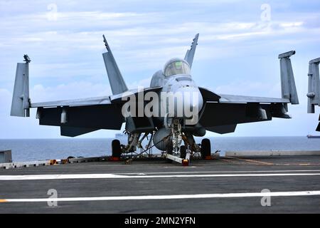 Eine F/A-18 Hornet sitzt auf dem Deck der USS Ronald Reagan (CVN 76). Soldaten der B Company, 3-2 General Support Aviation Bataillon, 2. die Combat Aviation Brigade führte am 26. September 2022 Decklandungen mit CH-47F Chinook-Hubschraubern auf dem einzigen vorwärts eingesetzten Flugzeugträger der US-Marine, USS Ronald Reagan (CVN 76), in den Gewässern östlich der koreanischen Halbinsel durch. Die Qualifikation für die Landung an Deck wird durchgeführt, um die Mitglieder der Luftbesatzung und Piloten bei der Landung auf einem Schiff zu zertifizieren. Diese Schulung wurde zum Teil im Rahmen der Maritime Counter Special Operations Exercise (MCSOFEX) durchgeführt, um Inter zu stärken Stockfoto