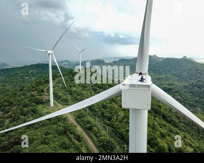 Zwei Windturbinentechniker arbeiten an der Gondel einer Turbine in der Sidrap Wind Farm in South Sulawesi, Indonesien. Stockfoto