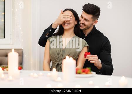 Ein hübscher junger Mann, der seine Freundin zum Hochzeitstag überraschte Stockfoto