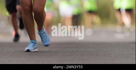 Gesunde Gruppe von Menschen joggen auf der Strecke in Asphalt Straße, um Gewicht zu verlieren Stockfoto
