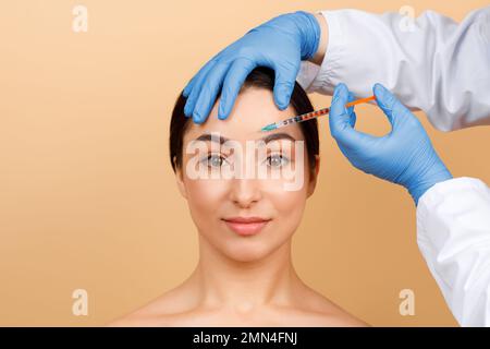 Kosmetologe Doktor Macht Botox-Injektion In Interbrow Zone An Junge Indianerin Stockfoto