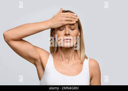 Frau mittleren Alters, die unter starken Kopfschmerzen leidet Stockfoto