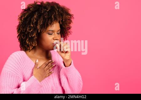 Traurige unglückliche junge, schwarze, lockige Frau mit leichtem Husten, die an Halsschmerzen leidet Stockfoto