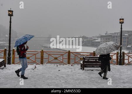 Srinagar, Indien. 30. Januar 2023. Die Bewohner laufen entlang der schneebedeckten Fußbrücke, während es in Srinagar schneit. Das Kaschmir-Tal war von der Außenwelt abgeschnitten, alle Flüge zum und vom Flughafen Srinagar wurden gestrichen und die Nationalautobahn wurde wegen starkem Schneefall am Montagmorgen gesperrt. Kredit: SOPA Images Limited/Alamy Live News Stockfoto